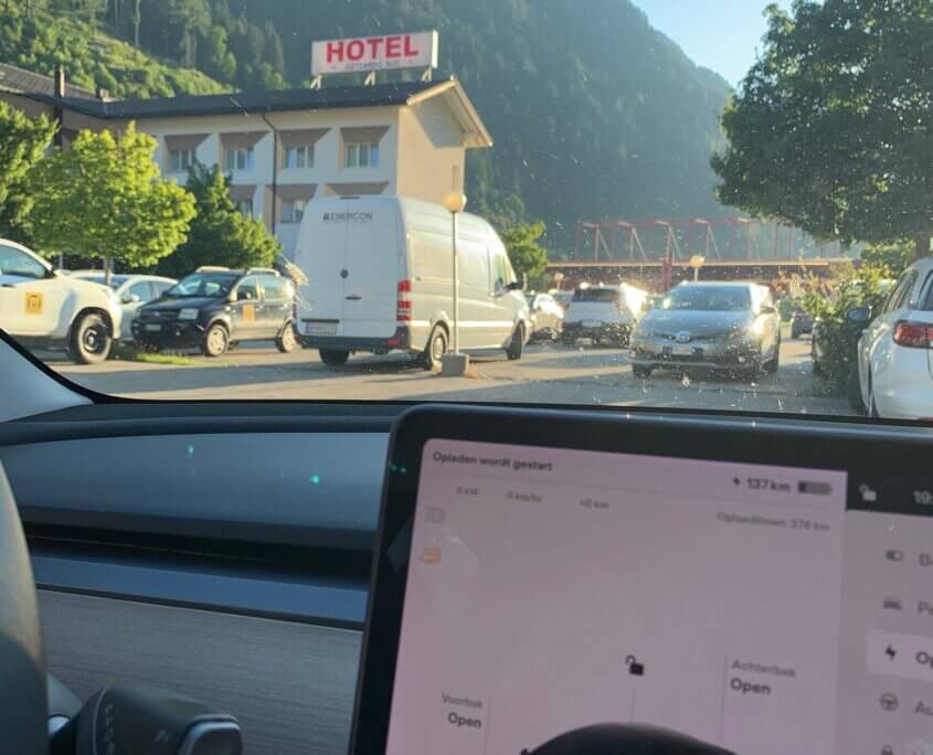 Tesla SuC na Gotthardtunnel bij Quinto naast hotel